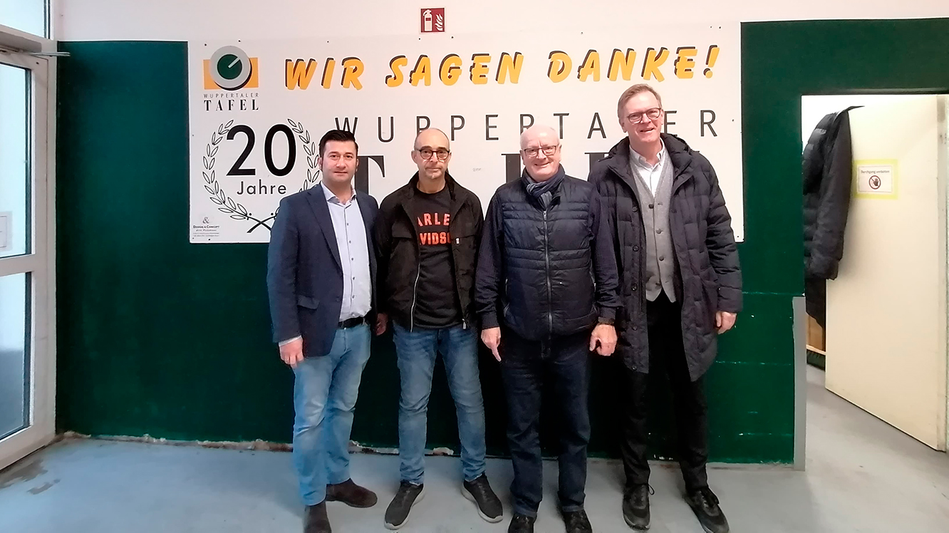 Repräsentanten der Wuppertaler Tafel und die Geschäftsführung von Bobotex stehen zusammen vor einem Schild mit dem Logo der Tafel.